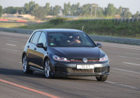 černý automobil s celoročními pneumatikami na dálnici